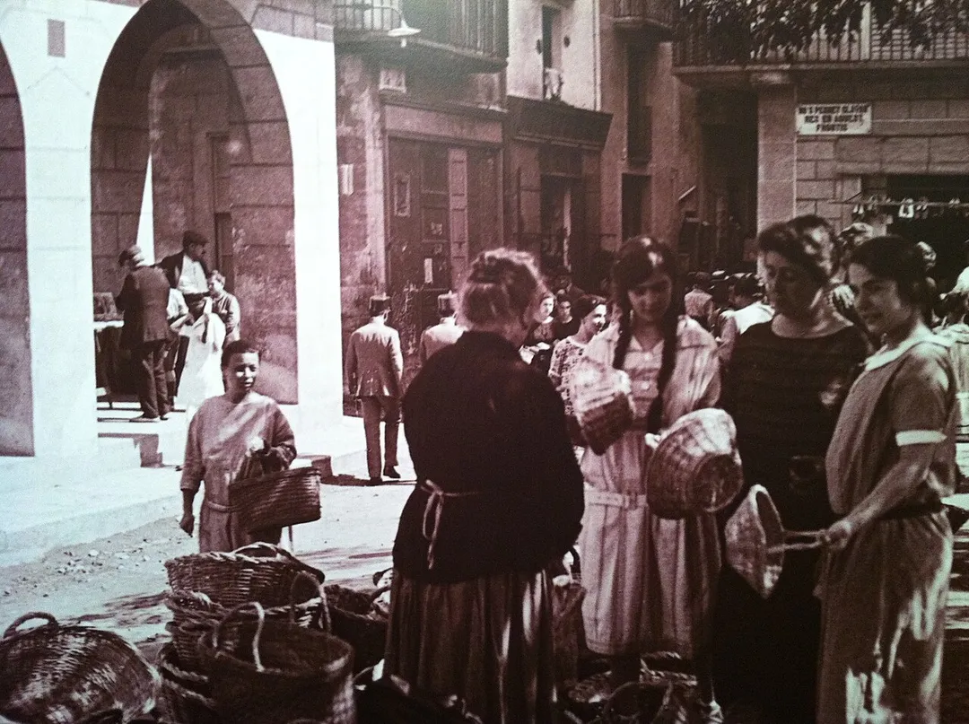 A scene of Catalan women at the market in Sant Feliu de Guíxols.