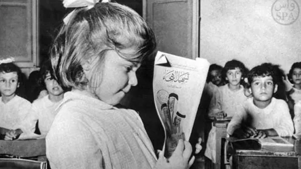 A young female pupil holds a book during a class in session in this undated picture