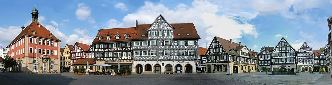 Marktplatz in Schorndorf, Deutschland,  mit dem Rathaus (links) und diversen Fachwerkhäusern, darunter Künkelinhaus, Palm'sche Apotheke, Gaupp'sche Apotheke und anderen, sowie dem Marktbrunnen und den Skulpturen "Fortschnittschritt" von Hüseyin Altin (links des Brunnens) und "Das Gespräch" von Max Seiz (rechts des Brunnens.