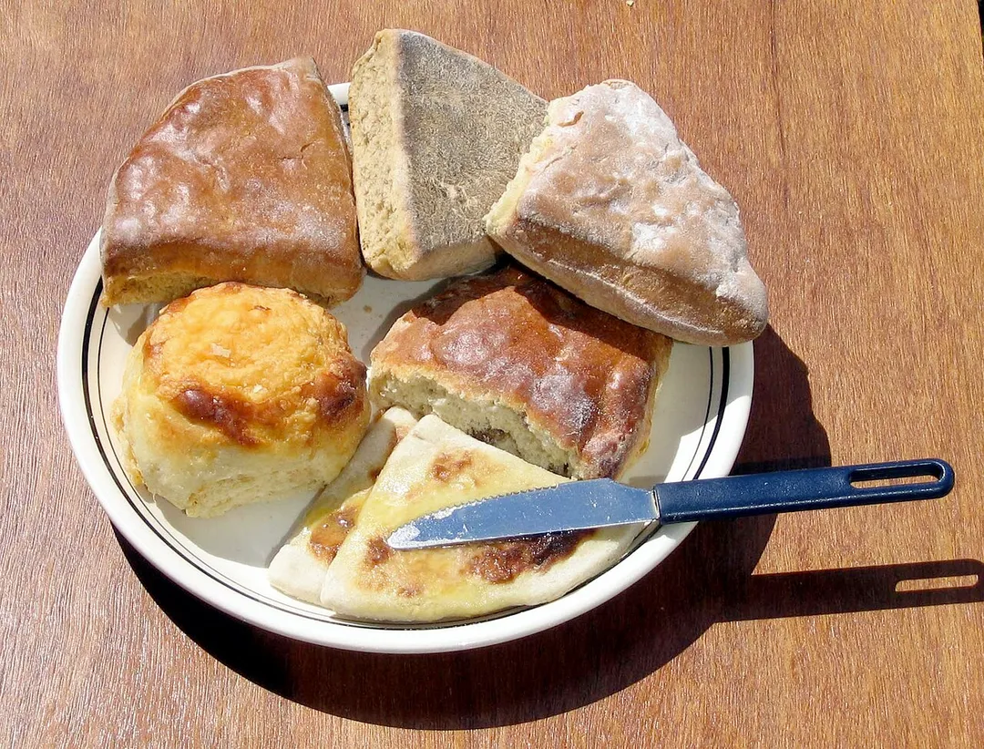 Various scones, from a baker's shop in Scotland.  As described at the time, hot buttered tattie scones next to a cheese scone, shiny and flat treacle scones, and a milk scone above a fruit scone.