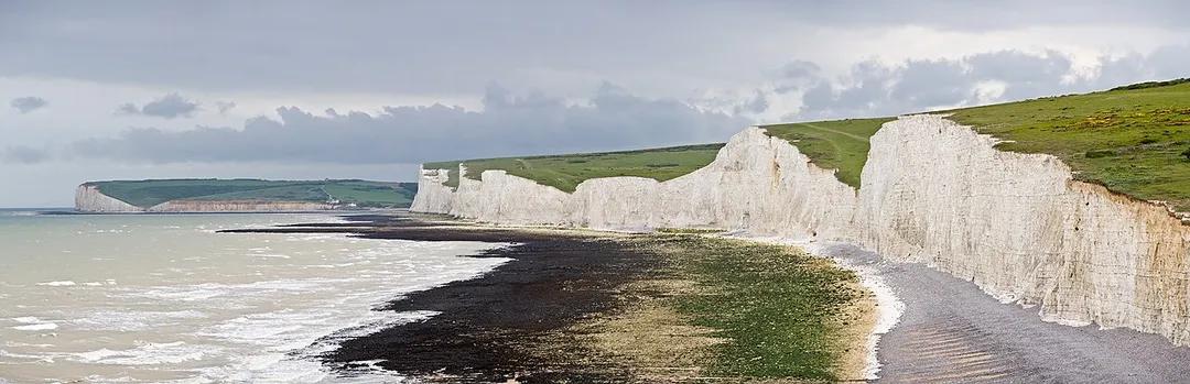 The Seven Sisters, a series of seven chalk cliff peaks along the East Sussex coast in England. Seaford head in the background is on the other side of the River Cuckmere and not part of the Seven Sisters. Taken by myself as a series of 7 frames with a Canon 5D and 70-200mm f/2.8L lens at 200mm.