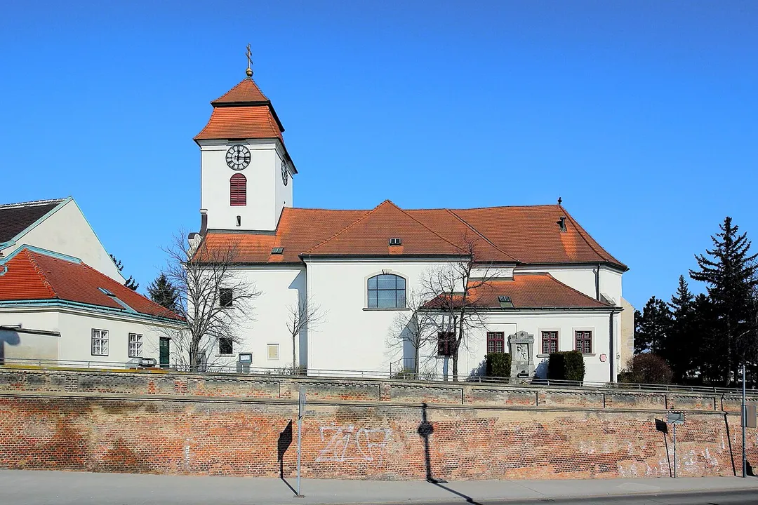 Südwestansicht der röm.-kath. Pfarrkirche hl. Laurenz (Altsimmeringer Pfarrkirche) in Simmering, ein Stadtteil der österreichischen Bundeshauptstadt Wien.