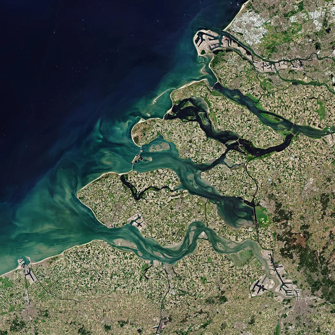 The Copernicus Sentinel-2 mission takes us over Zeeland – the westernmost province in the Netherlands.Zoom in to see this image at its full 10 m resolution.Located around 150 km from Amsterdam, Zeeland consists of a complex system of islands, peninsulas and waterways. It also comprises Zeeuwsch-Vlaanderen – a strip of the Flanders mainland between the Western Scheldt (Westerschelde) and Belgium.The province of Zeeland lies on the large river delta at the mouth of several rivers, like the Scheldt (Schelde) and Meuse (Maas) rivers. The lighter aqua colours in the image depict the shallow waters of the delta with riverbeds and several sandbanks visible. The brown coloured waters indicate a higher sediment content, which contrasts with the darker waters of the North Sea.The Port of Rotterdam, the largest seaport in Europe, is visible top-right in the image. Antwerp, in Belgium, is visible in the bottom-right and the quaint city of Bruges can be seen in the bottom-left of the image.Zeeland is one of the main agricultural provinces in the Netherlands with one of the largest areas of arable farmland. The patchwork of agricultural fields visible on the islands and mainland show the fields in the various stages of growth or harvest. The area supports cereals, potatoes, beets, cattle and horticulture.Large parts of Zeeland, which translates to ‘sea land,’ lie below sea level. The province was the site of a deadly flood in 1953 brought on by a combination of high spring tides and a strong windstorm that severely damaged the low-lying coastal region.As a result, the Dutch government began to implement the Delta Project – an elaborate system of dykes, canals, dams and bridges to hold back the North Sea. In this image, the 9km-long Eastern Scheldt Storm Surge Barrier (Oosterscheldekering) is visible between the islands of Schouwen-Duiveland and Noord-Beveland.Since sea-level rise is a key indicator of climate change, accurately monitoring the changing height of the sea surface over decades is essential for climate science, for policy-making and, ultimately, for protecting the lives of those in low-lying regions at risk.The Copernicus Sentinel-6 Michael Freilich satellite, set to launch in November, is the first of two identical satellites to be launched sequentially to provide accurate measurements of sea level change.Both satellites will reach 66°N and 66°S – a specific orbit occupied by the earlier missions that supplied the reference sea-surface height data over the last three decades. This orbit will allow for 95% of Earth’s ice-free ocean to be mapped every 10 days.This image, acquired on 30 May 2020, is also featured on the Earth from Space video programme.