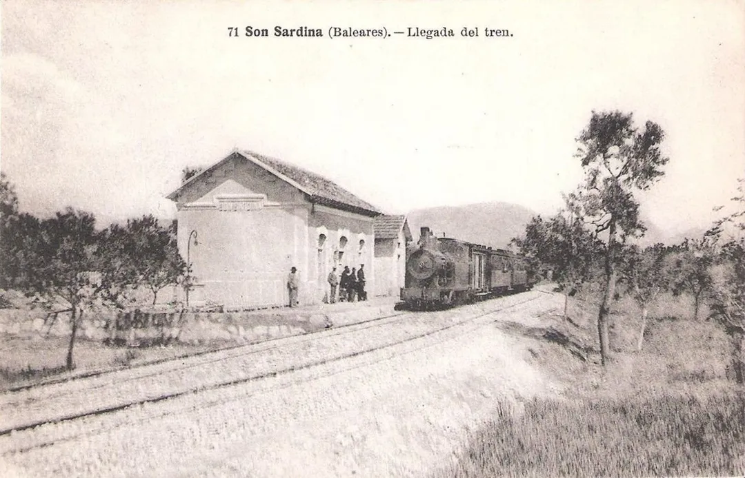 Depicts Son Sardina station (Mallorca, Balearic Islands, Spain) with a steam train arriving. 
Image from the early years of the Palma–Sóller railway (opened 1912).