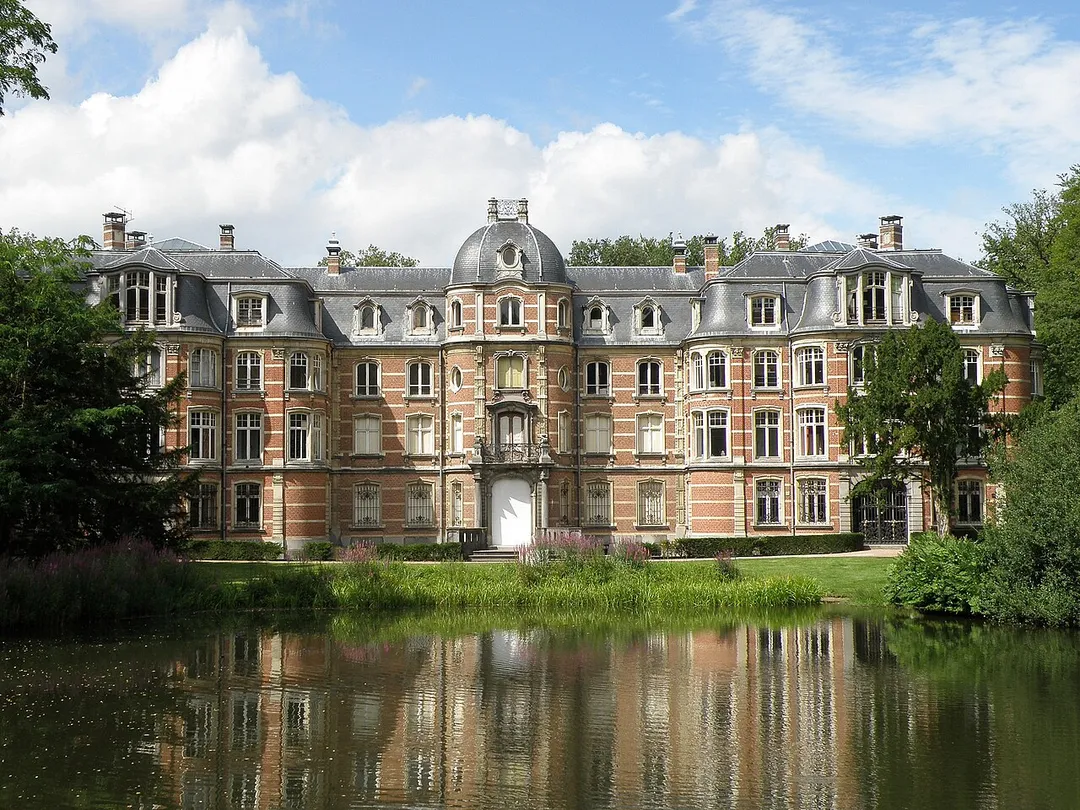 Stabroek, comm. dans la prov. d'Anvers (Belgique), à la frontière hollandaise. Château Ravenhof, de style néo-rococo, édifié pour partie début XIXe, pour partie début XXe. Arch. Fr. Stuyck. Parc s'étendant de part et d'autre de la frontière. Gloriette en territoire hollandais. Sur la photo : façade sud (arrière, côté jardin).
