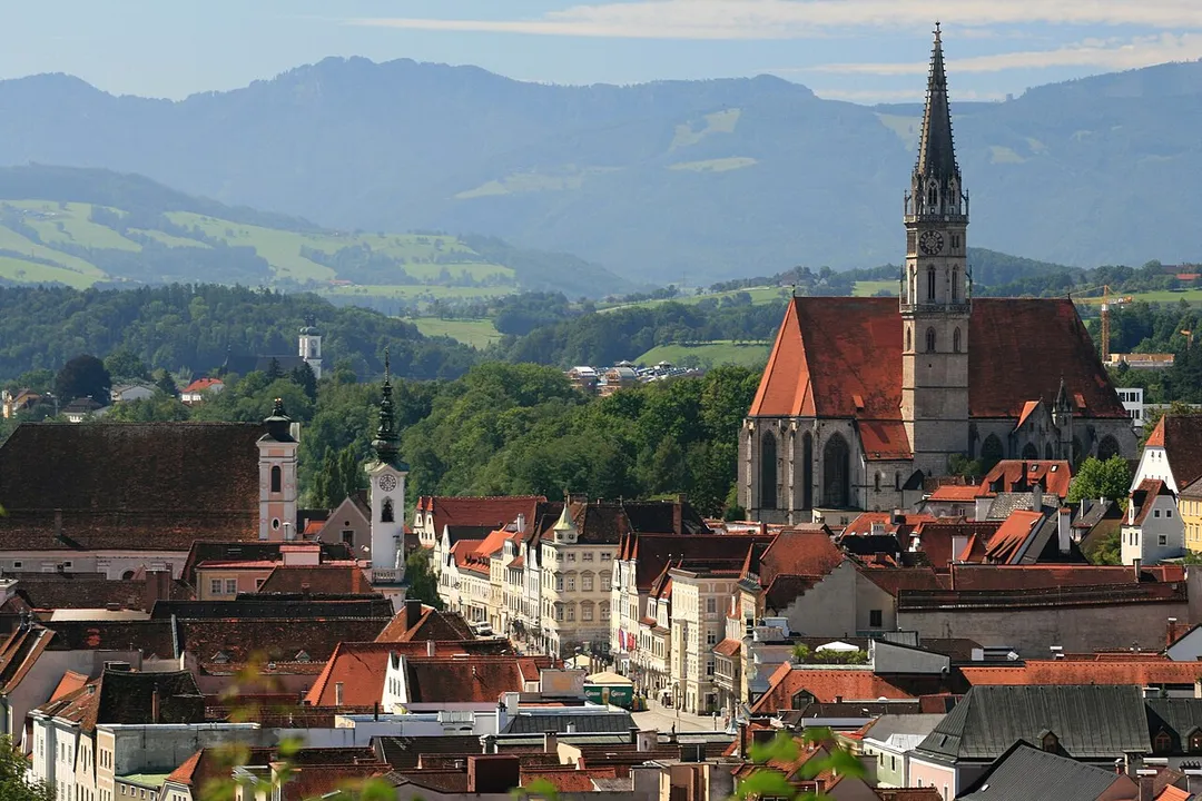 Blick über die Steyrer Altstadt. Links am Stadtplatz liegen das Rathaus (mit Turm) und dahinter die Marienkirche. Das dominante Gebäude in der rechten Bildhälfte ist die Stadtpfarrkirche Steyr. Im Hintergrund links die ehemalige Stiftskirche Garsten. Das Gebäude mit dem auffallend vorspringenden Erker rechts schräg vor dem grünen Lastwagen ist das gotische Bummerlhaus, eines der ältesten Gebäude der Stadt und das Steyrer Wahrzeichen. Aufgenommen wurde das Foto vom Taborturm aus.