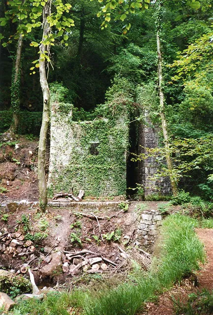 Stithians: Kennall Vale Gunpowder Works. The 19th century gunpowder works was water-powered, employing leats from the river Kennall. The buildings shown here once had an overshot waterwheel in the gap, powering edge runners in incorporating mills on either side. The gunpowder works supplied many of the mines of west Cornwall until 1910, by which time gunpowder had been largely replaced by high explosives. The site is now within a Nature Reserve