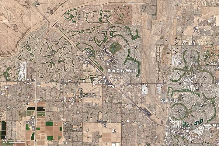 When the real estate developer Del Webb conceived Sun City in the 1950s, the goal was something unheard of at that time: build a retirement community specifically for adults. It was fitting, then, that the layout of the community be equally distinctive.
Amidst the rectangular grids that make up most neighborhoods in the greater Phoenix area, Sun City’s radial streets, curving lines of homes, and verdant golf courses are hard to miss when seen from above. At the center of the circular neighborhoods are community buildings: mainly churches, with a few stores and health care facilities mixed in. Pools, tennis courts, pickle ball courts, and bowling alleys are squeezed in between the many single-levels homes that dominate Sun City.
The retirement community concept proved wildly successful when Sun City was unveiled in 1960 with just five model homes, a recreation center, one golf course, and one shopping center. The opening weekend drew more than 100,000 people—far more than expected—and inspired a cover story in Time. Decades later, the age-restricted community has seven pools, eight golf courses, and some 40,000 residents.
Sun City proved so successful that several more retirement communities were built just to the west. A few of them include golf courses with distinctive layouts that are reminiscent of flowers when viewed from above.

The Operational Land Imager (OLI) on Landsat 8 captured this image of Sun City, Arizona, on May 25, 2016.