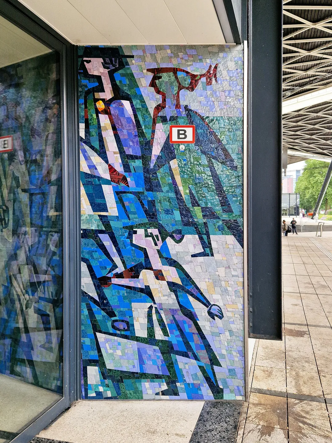 Glass mosaic panel at the entrance of Tilburg Central Station by artist Piet Buys. The mosaic panels show travellers hurrying to and from the station.