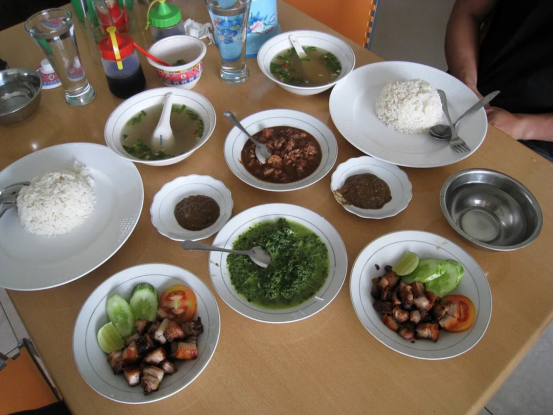Batak cuisine, the saksang pork stew cooked in its blood and spices, and panggang grilled pork, with sayur daun ubi (singkong) tumbuk or pounded cassava leaf vegetables and broth soup.