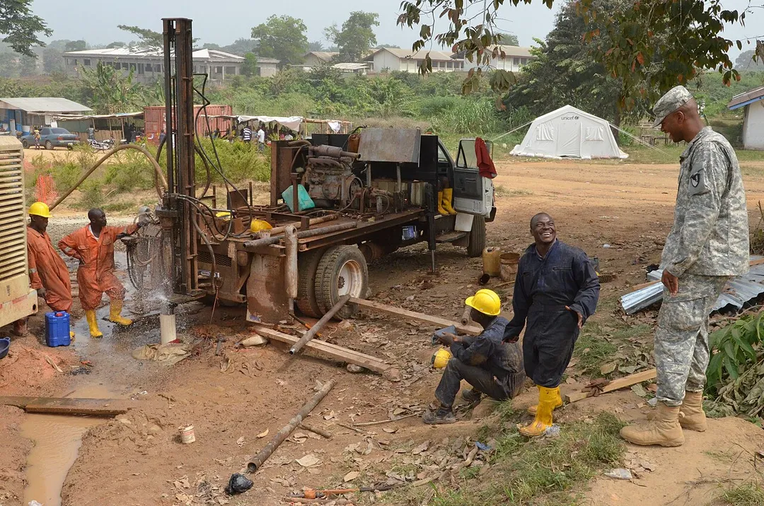 First Lt. Jordan Springer, right, an Atlanta native and contracting officer representative for the 104th Engineer Company, 62nd Engineer Battalion, 36th Engineer Brigade, based out of Fort Hood, Texas, asks a Liberian worker about making adjustments on the pipe for a well at an Ebola treatment unit, Tubmanburg, Liberia, Jan. 13, 2015, in support of Operation United Assistance. Springer supervised the Liberian workers as they completed the water well, which will provide water for the ETU. Operation United Assistance is a Department of Defense operation in Liberia to provide logistics, training and engineering support to U.S. Agency for International Development-led efforts to contain the Ebola virus outbreak in western Africa. (U.S. Army photo by Sgt. Ange Desinor 13th Public Affairs Detachment/RELEASED)