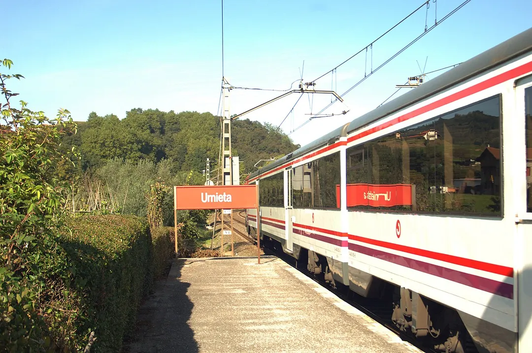 Señalización y andén lateral de la estación con un cercanías llegando