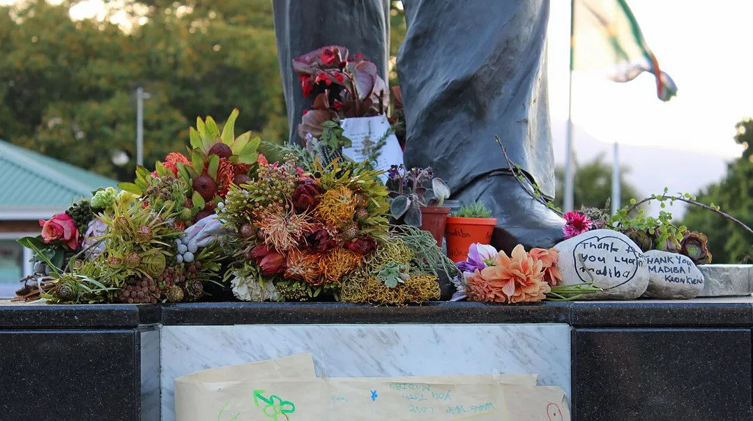 Flowers laid outside Drakenstein Correctional Centre, with South African flag flying half-mast in the background, during the national mourning period for Nelson Mandela.