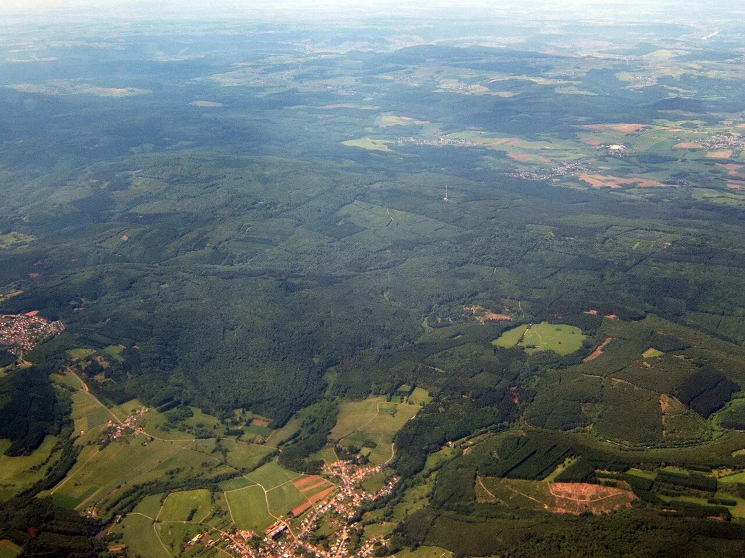 Aerial view of parts of Wadern, Germany with large forests to the north (all belonging to the huge Naturpark Saar-Hunsrück). The parts of Wadern that can be seen are Wadrill (bottom-center) and Steinberg (left).