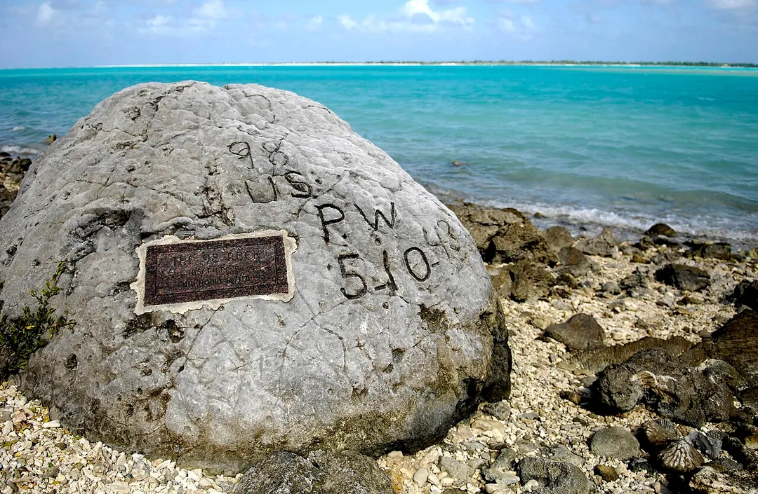 The "98 Rock" is a memorial for the 98 U.S. civilian contract POWs who were forced by their Japanese captors to rebuild the airstrip as slave labor, then were blind-folded and killed by machine gun Oct. 5, 1943. An unidentified prisoner escaped, and chiseled "98 US PW 5-10-43" ("98 US Prisoners of War 5 October 1943") on a large coral rock near their mass grave, on Wilkes Island at the edge of the lagoon. The prisoner was recaptured and beheaded by the Japanese admiral, who was later convicted and executed for war crimes. (U.S. Air Force photo/Tech. Sgt. Shane A. Cuomo)