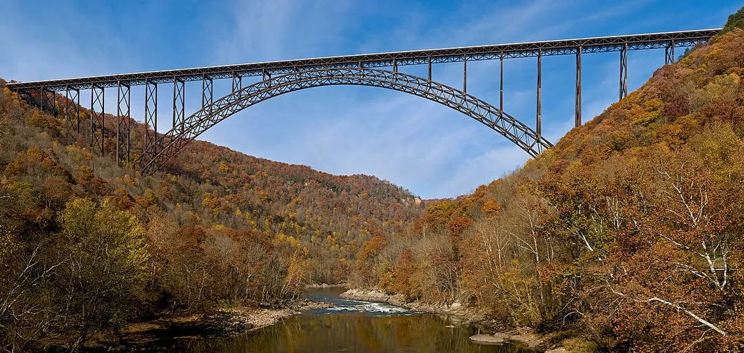 The New River Gorge Bridge in Fayetteville, West Virginia is a steel arch bridge that carries US 19 over the New River. It opened in 1977 and is the longest and highest steel arch bridge in the Western Hemisphere at 3030 ft (924 m) long and 876 ft (267 m) high. The bridge hosts Bridge Day, an annual event in which it closes to vehicles, and participants are allowed to BASE jump to the valley floor below.