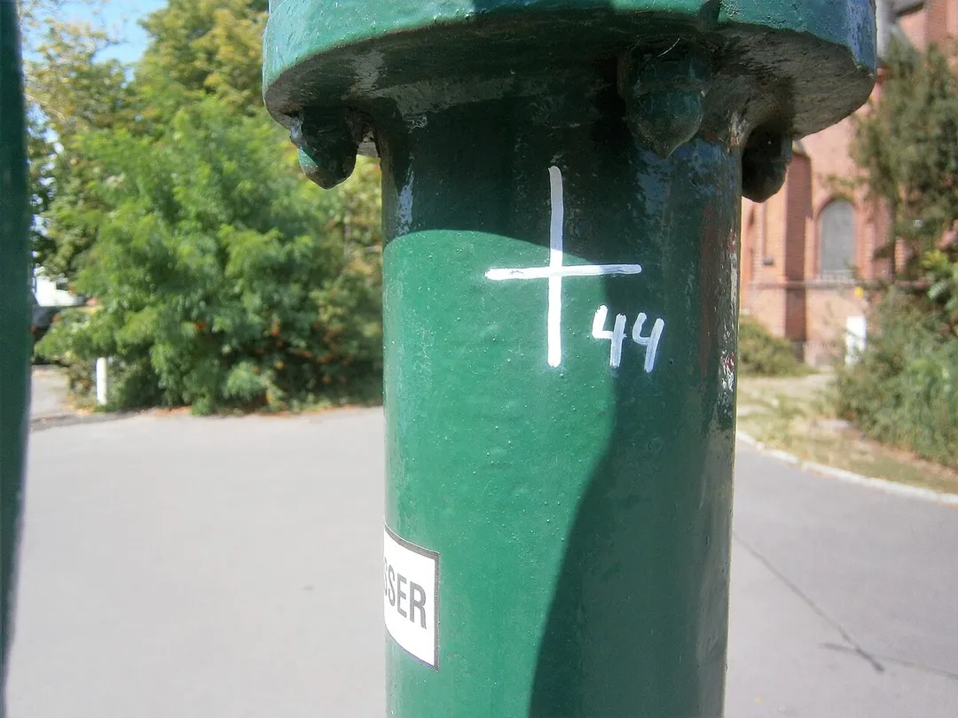 Auf dem gelisteten Grundstück Adamstraße 24 (Drucksache zur Anfrage 17-15418) steht das Gebäude der Paul-Mohr-Schule[1] und das Grundstück liegt östlich vom Melanchthonplatz.[2] Der Schulbau entstand 1930. Für eine Umsetzung des Brunnens gibt es keine Anzeichen. Der Standort des Brunnens liegt am Norden des Melachthonplatzes am Gehwegrand des Parkplatzes der die Adamstraße verlängert. Der Bogen in der  Straßenführung erfolgte in den 1960er Jahren, zuvor verlief die Adamstraße im Süden der Melanchthonkirche gerade und die Melanchthonstraße kreuzte rechtwinkling mit dem Verlauf auf dem Westen des Schulgeländes. Die direkte Führung über die Wilhelmstraße zur Schmidt-Knobelsdorf-Straße erfolgte unter Nutzung der Kolonie Diederich. Dadurch wurde der Melchthonplatz mit dem Kirchenbau neu gefasst. Gegenüber der Kirche auf der Brunnenseite steht ein Seniorenwohnhaus[3] Der Brunnenstandort entspricht dem Rand des südlichen Gehwegs. Deer Austritt ist an einer langen Hülse verschraubt und der Abfluss gelangt auf die Gehwegplatten zwischen Parkfläche und Ausfahrt vom Heim. Der FSH-Brunnen steht mindestens seit Beginn der 2000er Jahre.