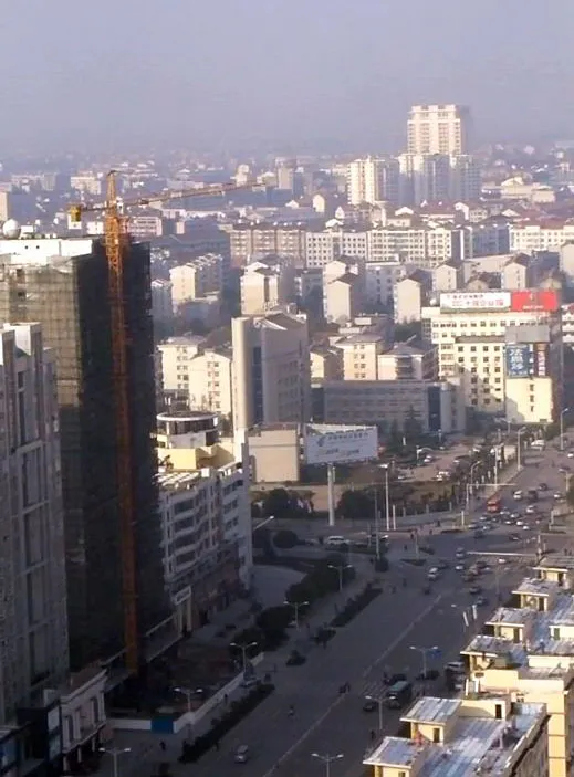 Looking west along Qiankun Avenue (乾坤大道) over its intersection with Beijing Road (北京路) from the 27th floor of the Qiankun Business Hotel towards central Xiaogan's southern area.  Xiaogan is about 60 km northwest of the capital of Hubei province, Wuhan.  Screen capture of a video taken at 9:30 local time.  +Auto levels in Adobe Photoshop Elements 6.0