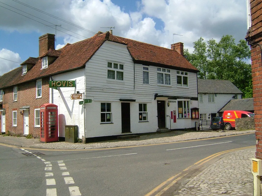 Yalding, the junction of High Street and Lees Road showing the post office, with telephone box. The building is white shiplap, with Kentish peg tile roof, behind building with decorative brickwork, and dormer window in the pegtile roof. This spot lies on the Greensand Way, and the Heart of Kent Country Tour.
Camera location51° 13′ 24.6″ N, 0° 25′ 44.4″ E View this and other nearby images on: OpenStreetMap 51.223500;    0.429000