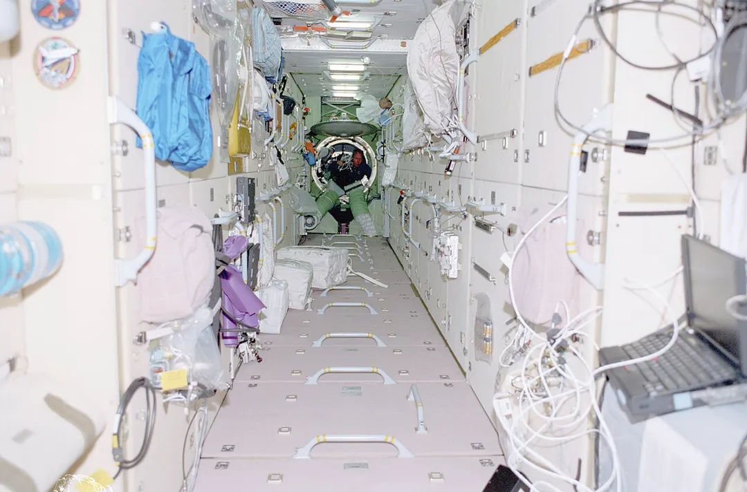 Mission Specialist Thomas Jones floats through the Zarya Functional Cargo Block (FGB) carrying hardware for the IMAX Camera. Photos were taken during Mission STS-98, International Space Station (ISS) Flight 5A. Image ID: sts098-338-023